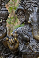 Close-up of traditional wooden carving of Hindu god Ganesha with elephant head, symbol of wisdom, prosperity, and protection in Indian spirituality.