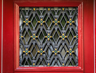 Decorative wrought iron quatrefoil grate on a wooden door in Zurich, Switzerland