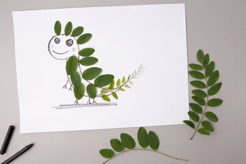 Nature-inspired dinosaur craft using green leaves and crayon, ideal for educational publishers, DIY blogs, eco-friendly brands, promoting kids creativity and sustainable art,