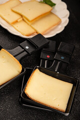 Raclette cheese portion slicing natural product tasty snack fresh delicious gourmet food background on the table rustic top view copy space