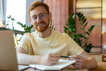 Bearded man multitasking between laptop and pizza meal