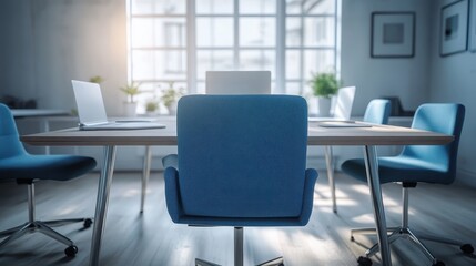 Modern Office Meeting Space with Empty Blue Chair and Laptops