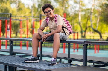 African american teen sitting at the playground after school
