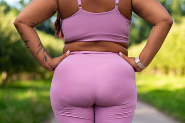 Closeup of plus size female back and buttocks in pink sportswear