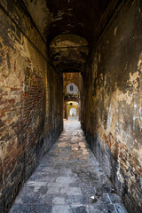 Fototapeta premium Exploring a narrow historic passageway adorned with unique doors from different cultures