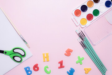 School supplies on a colorful background. Back to school background. Brushes, watercolors, pencils, ballpoint pens