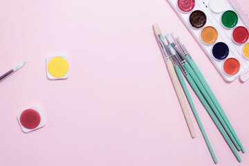 School supplies on a colorful background. Back to school background. Brushes, watercolors, pencils,...