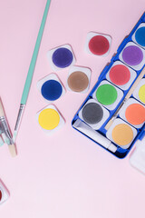 School supplies on a colorful background. Back to school background. Brushes, watercolors, pencils, ballpoint pens