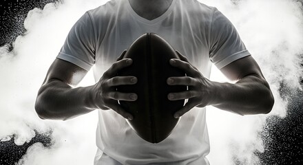 Person holding American football with both hands against dramatic smoke background, powerful sports concept showing strength, focus, and game intensity