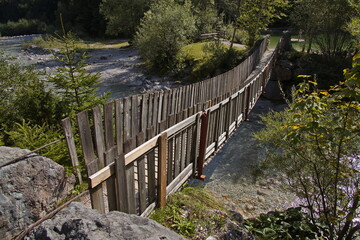 Fototapeta premium Wooden footbridge over creek Ödenbach at Vorderkaserklamm at St. Martin bei Lofer, Austria, Europe 