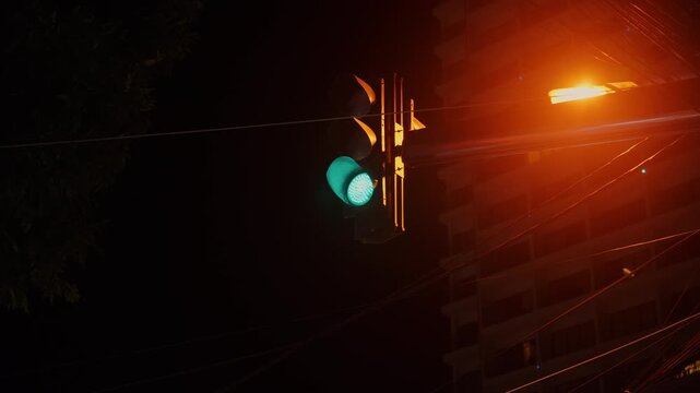 traffic light switches from green to red at night at an intersection