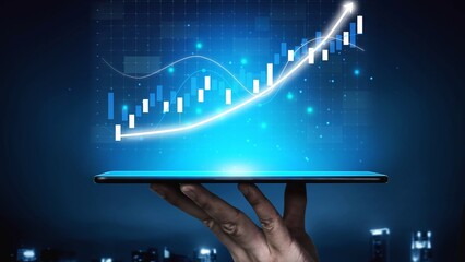 A hand holds a tablet displaying a rising graph, signifying financial growth and trends in a modern digital space, ideal for business and finance themes. Copula