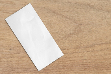 Cash receipt paper on oak wood table. blank purchase bill invoice or supermarket shopping retail...