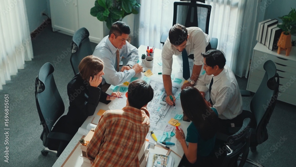 Poster group of diverse team planning strategy while sitting at table with project plan. top aerial view of