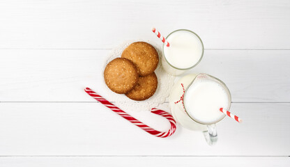Close up traditional christmas milk jug with cookies on Christmas lights background. Festive food, Christmas celebration traditions. Milk for Santa Claus. Top view