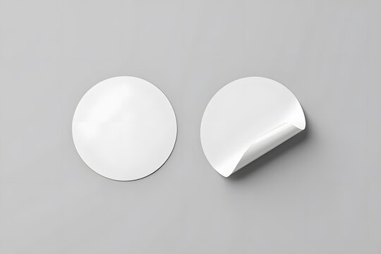 Two blank white oval stickers on a plain gray background