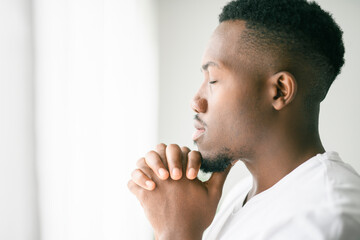 black man confident and casual at home. Portrait or headshot of a young men pray