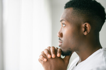 black man confident and casual at home. Portrait or headshot of a young men pray