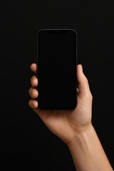 Hand Holding Smartphone with Blank Screen Against Solid Black Background for Showcase and Advertising