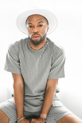 Portrait of black fashion American wearing great looking clothes with white hat