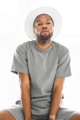 Portrait of black fashion American wearing great looking clothes with white hat