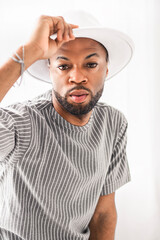 Portrait of black fashion American wearing great looking clothes with white hat