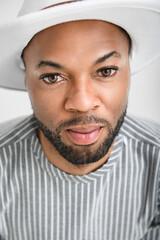 Portrait of black fashion American wearing great looking clothes with white hat