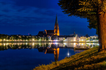 Fototapeta premium Dramatic Night View Of A German City With A Church Spire Reflected In The Water