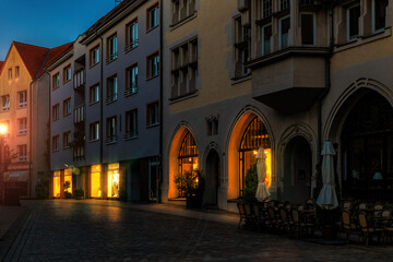 A Cozy European Street Scene at Dusk with Warm Light from the Windows