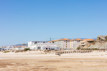 Obraz premium View of Tarifa beach with modern apartment buildings and coastal structures under a clear blue sky. Tarifa. Spain. September 2025.