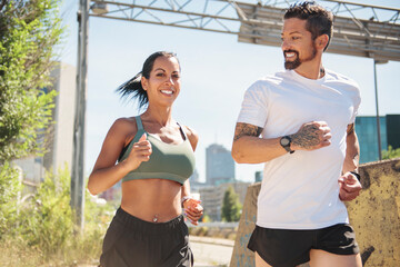 Young fitness couple running on a city on summer day