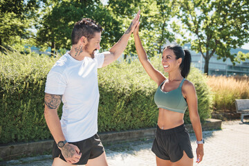 Young fitness couple running on a city on summer day