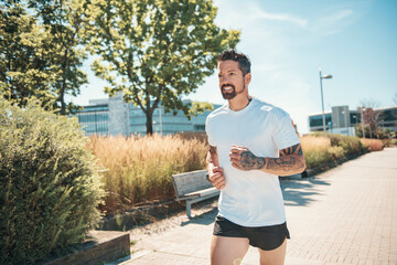 sporty man jogging outdoors in urban scene