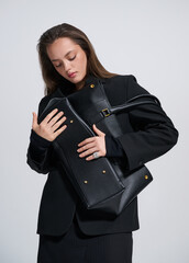 Girl model in stylish clothes with bag posing in studio