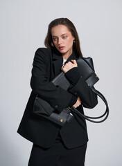 Girl model in stylish clothes with bag posing in studio