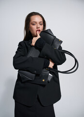 Girl model in stylish clothes with bag posing in studio