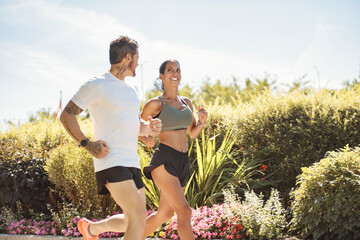 Young fitness couple running on a city on summer day