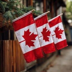 Three canadian flags hanging outdoors in a patriotic display today