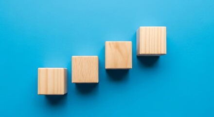 Four wooden blocks arranged in a rising staircase on blue background