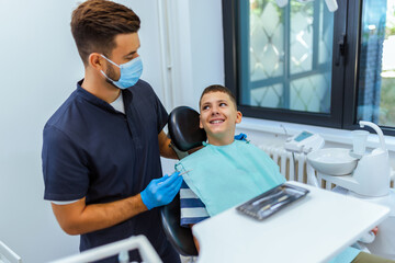 Fototapeta premium Dentist Examining Boy’s Teeth in Modern Dental Clinic
