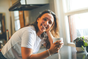 happy woman drinking coffee on the kitchen in the morning.