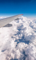 Obraz premium View from the airplane window at a beautiful cloudy sky and the airplane wing