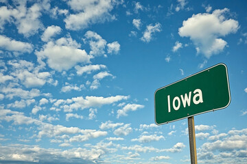 Roadside Greetings: The Iowa State Sign Beneath a Canvas of Blue and Clouds