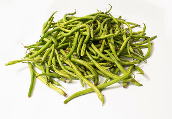 Rotten green beans in a bowl on a white background, showing mold and spoiled texture.