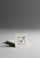 Simple Sticky Note with Checkmark on White Notebook Against Soft Grey Background for Organization and Task Completion Concept