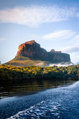 Tabletop mountain tepui in Canaima National Park, Venezuela at sunrise, with river and tree