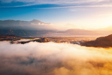 Fototapeta premium Aerial view of the alpine Lake Bled covered in morning mist from the Osojnica viewpoint. Location place Julian Alps, Triglav national park, Slovenia, Europe.