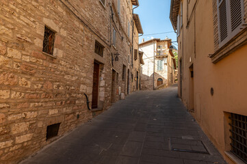 Naklejka premium Beautiful Tuscan historical street and place in the city of Assisi, Tuscany, Italy, Europe. Medieval atmosphere