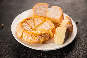 Cheese plate camembert, brie, munster french cheese tasty snack fresh delicious gourmet food background on the table rustic food top view copy space