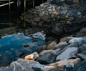 Rocks and old chains in the water by the docks